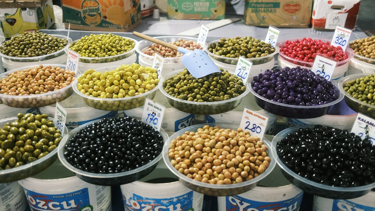 Colorful varieties of olives displayed in containers at an Istanbul market.